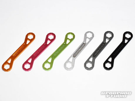 Sechs doppelseitige Schlüssel (Lock Nut Schlüssel) des Hedgehog Studio Trust Wrench Ver.3 – orange, rot, grün, silber, grau und schwarz – sind auf weißem Grund angeordnet. Alle haben die gleiche Form; das Hedgehog Studio-Logo erscheint unten rechts.