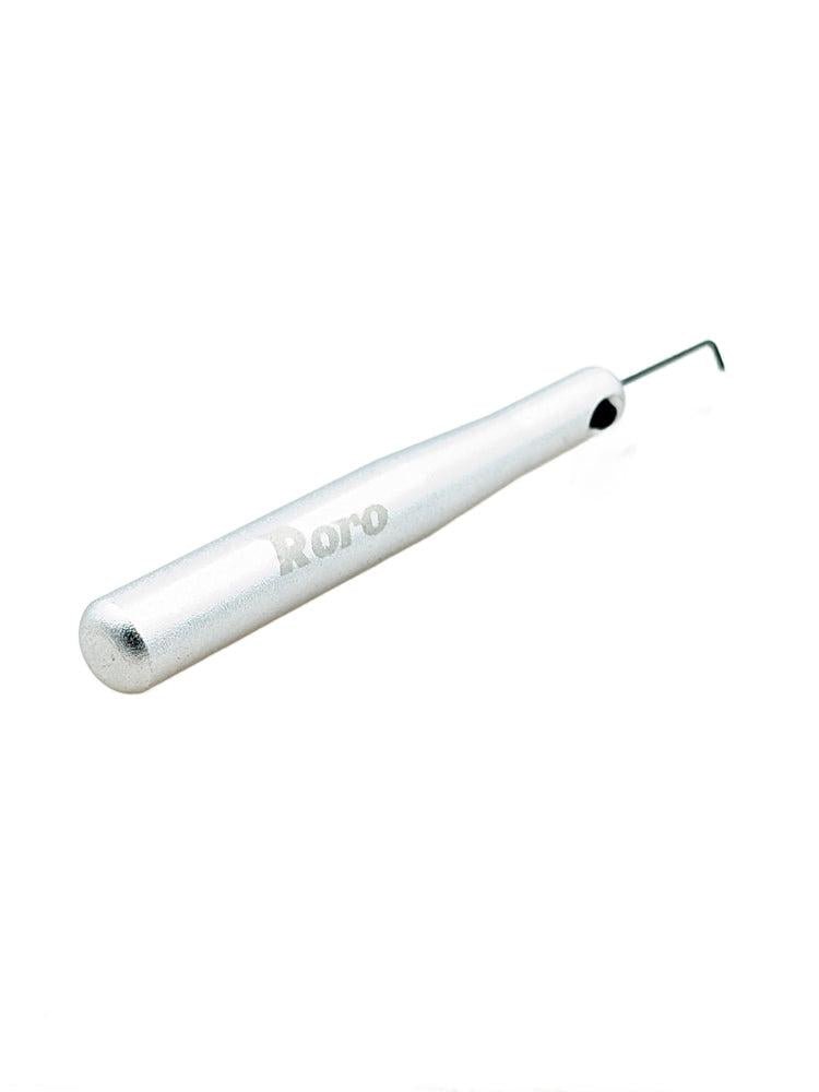 Ein Silbergriff-Knopfkappenentferner von Roro Lure mit einem strukturierten Griff und einer dünnen, abgewinkelten Spitze wird vor einem weißen Hintergrund gezeigt.